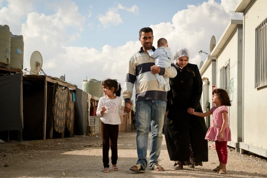 A family walking through the street in a camp of barracks. A family walking through the street in a camp of barracks.