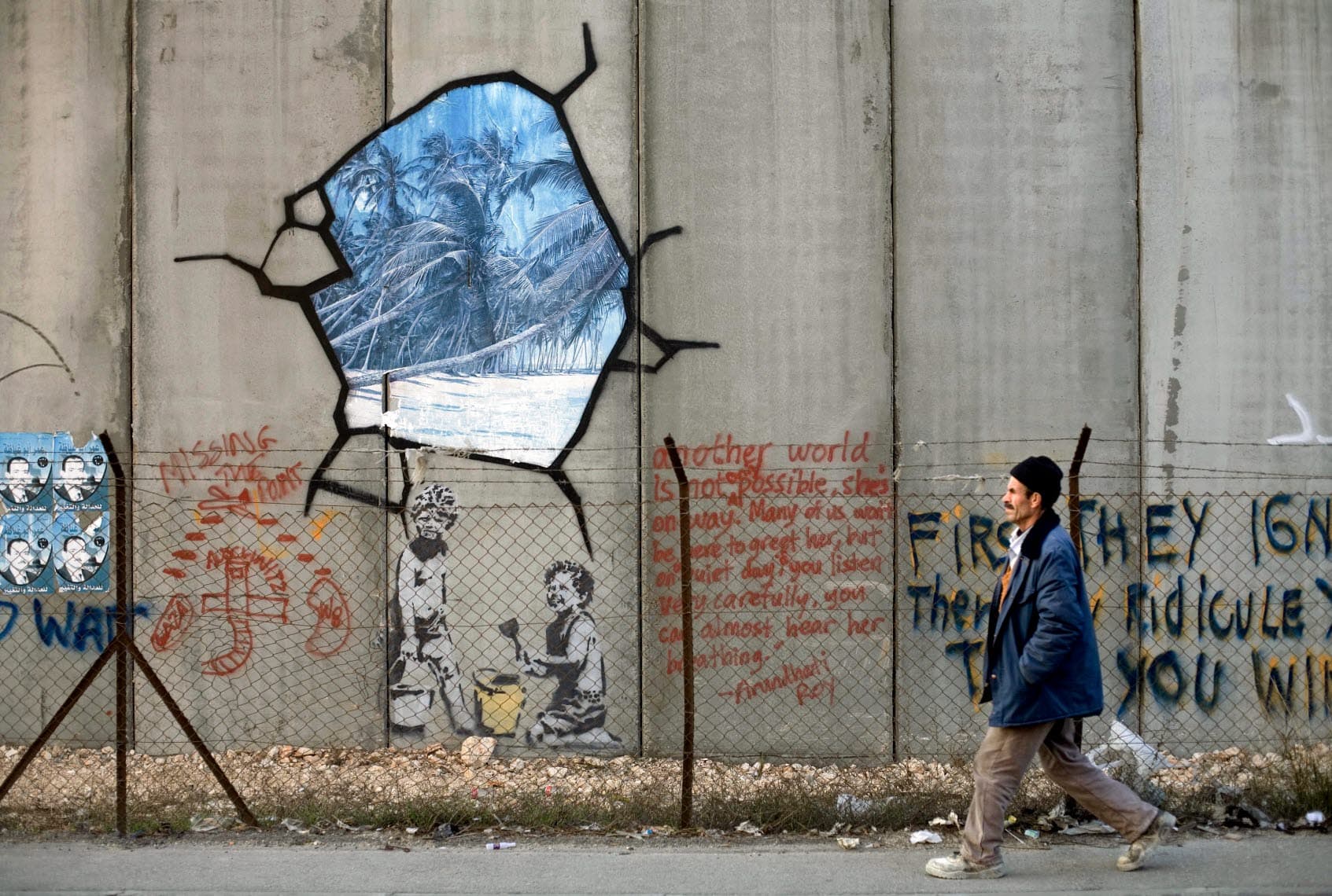 A man passes graffiti on a high wall. A man passes graffiti on a high wall.