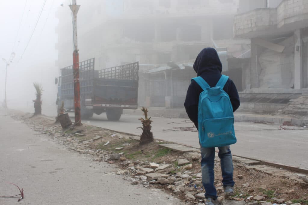 A child watching a truck that carries humanitarian aid. A child watching a truck that carries humanitarian aid.