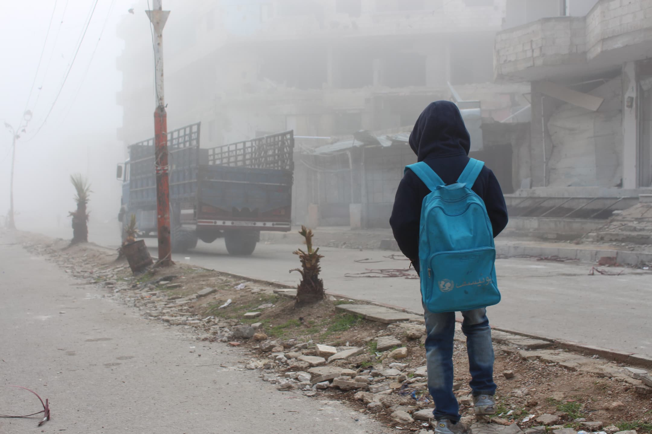 A child watching a truck that carries humanitarian aid. A child watching a truck that carries humanitarian aid.