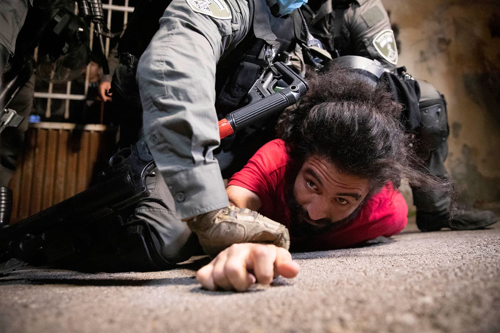 A person pressed down to the street by a security officer. A person pressed down to the street by a security officer.